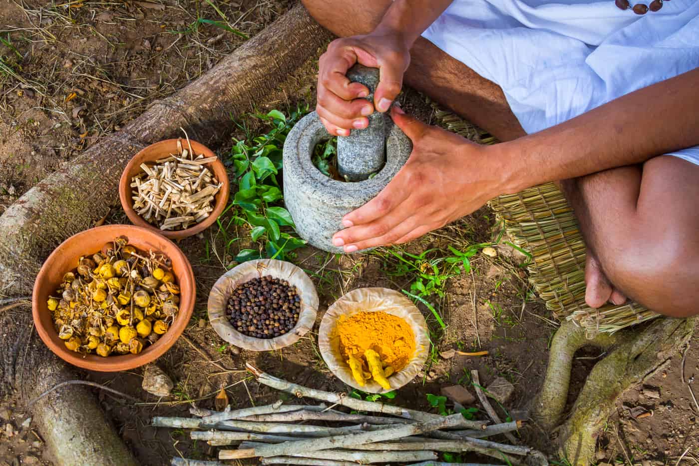 A young man preparing ayurvedic medicine in the traditional mann